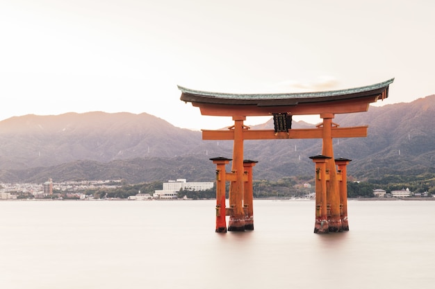 Santuário de Itsukushima em um lago cercado por colinas cobertas de vegetação no Japão