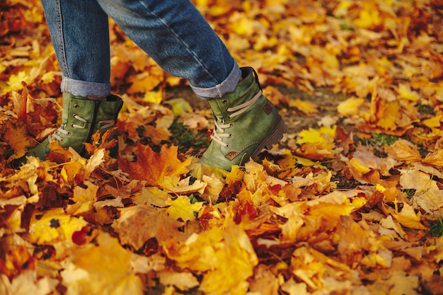 Sapatos de couro andando nas folhas de outono