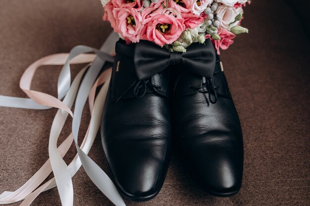 Sapatos de noivo com flores e laço