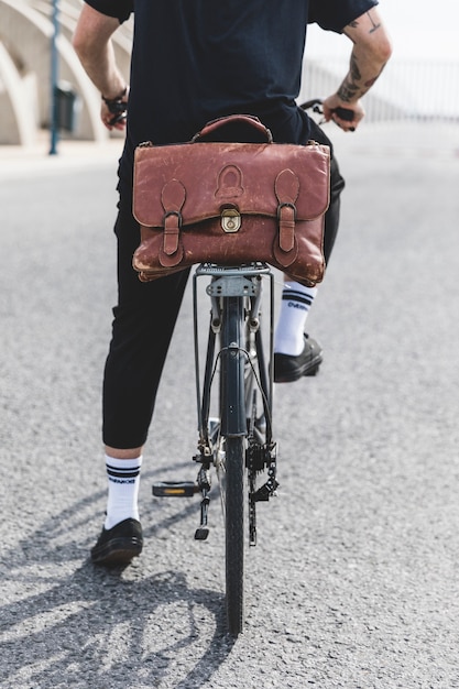 Seção baixa de um jovem andando de bicicleta na estrada