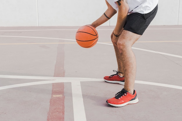 Foto grátis seção baixa, vista, de, um, homem, prática, basquetebol, em, corte