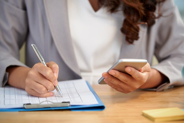 Seção intermediária da mulher anônima que trabalha com documento de negócios