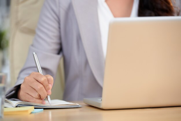 Seção intermediária da mulher cortada, copiando dados importantes do computador laptop