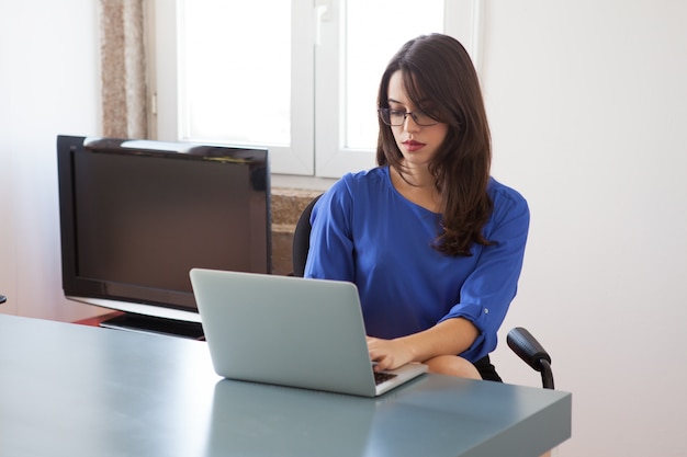 Secretária ocupada que prepara o relatório no laptop