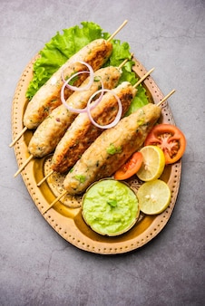 Seekh kabab feito com frango picado ou keema de carneiro, servido com chutney verde e salada