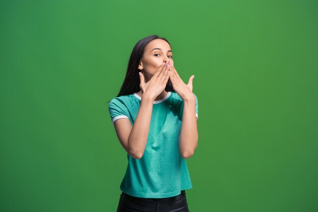 Segredo, conceito de fofoca. Jovem mulher sussurrando um segredo por trás da mão.