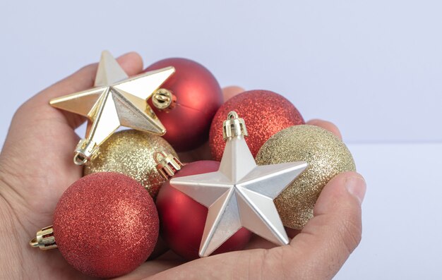 Segurando as estrelas e as bolas da árvore de Natal na mão