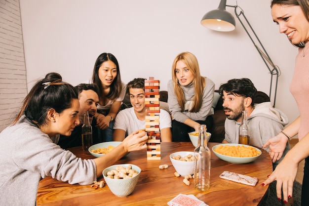 Seis amigos alegres jogando o jogo de mesa