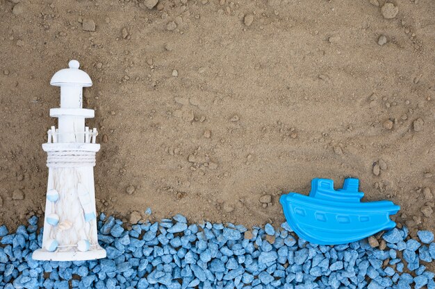 Foto grátis seixos azuis leigos planos com farol e barco na areia