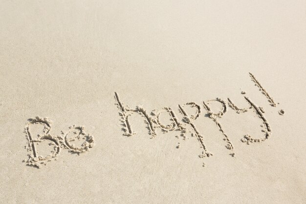 Seja feliz escrito na areia