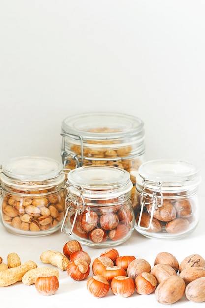 Foto grátis seleção de nozes diversas: avelãs, pistache e nozes-pecã em vidro