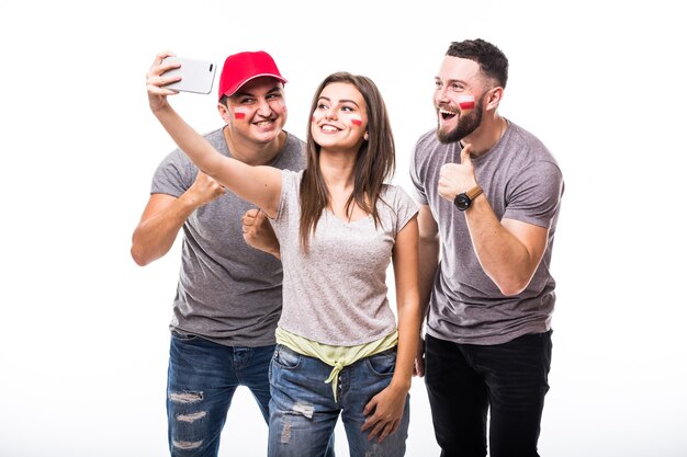 Selfie no telefone do fã de futebol da Polônia em jogo de apoio das seleções nacionais da Polônia em fundo branco. Conceito de fãs de futebol.