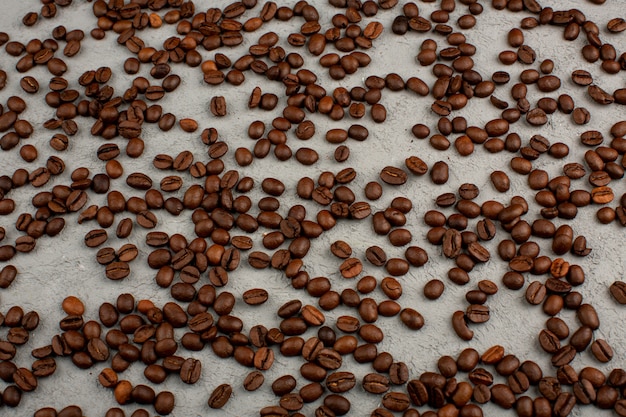 Sementes de café marrons na mesa cinza