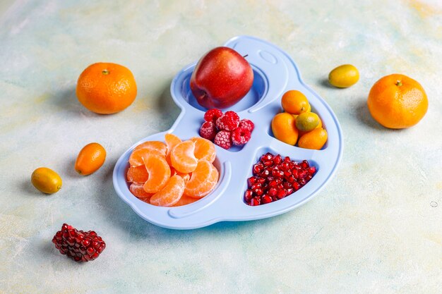 Sementes de romã frescas, fatias de tangerina e frutas de kumquat.
