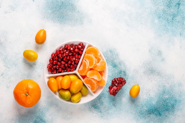 Foto grátis sementes de romã frescas, fatias de tangerina e frutas de kumquat.