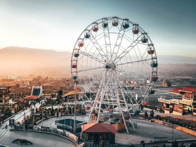 Sempre divertido ver uma roda gigante alta quando se aproxima do parque em férias cheias de pessoas felizes