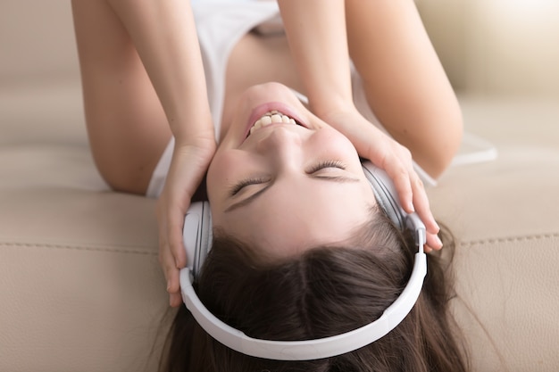 Foto grátis senhora alegre, apreciando a música popular em fones de ouvido