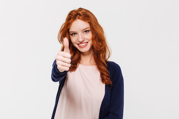 Senhora alegre jovem ruiva mostrando os polegares.