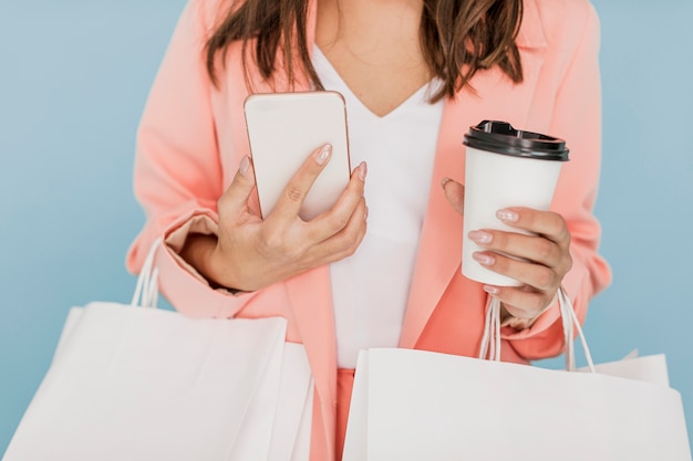 Foto grátis senhora com café e smartphone em fundo azul