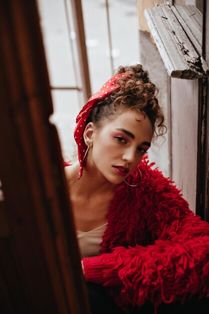 Senhora confiante em roupa vermelha elegante olha para a câmera