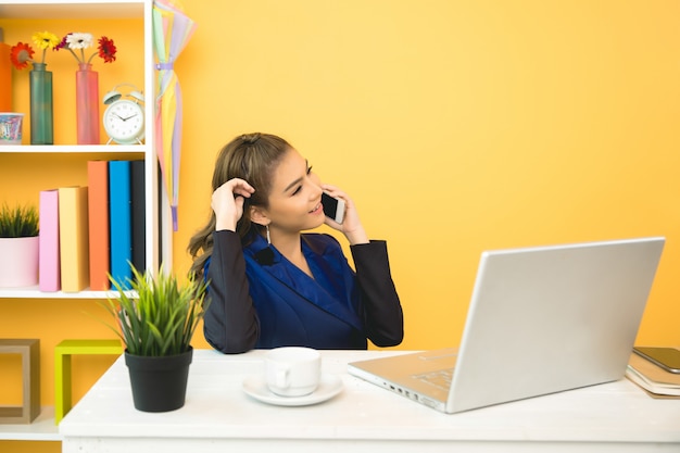 Senhora de negócios alegre trabalhando no laptop no escritório