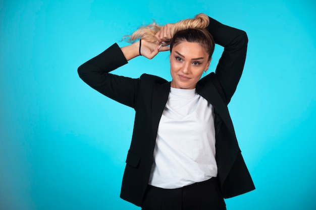 Foto grátis senhora de negócios em blazer preto, fazendo o penteado.