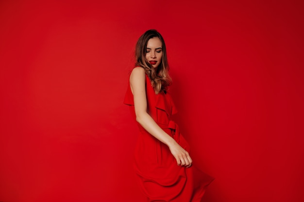 Foto grátis senhora encantadora brincalhona de vestido vermelho dançando e se divertindo