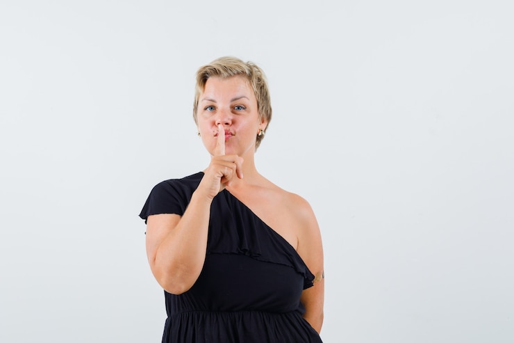 Foto grátis senhora encantadora de blusa preta mostrando gesto de silêncio