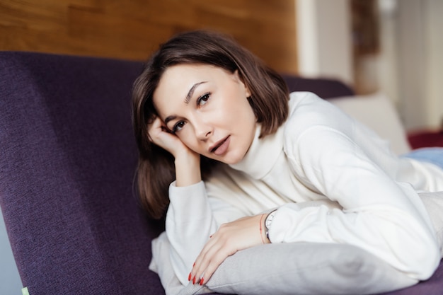 Senhora encantadora é relaxante na cama em casa depois do trabalho