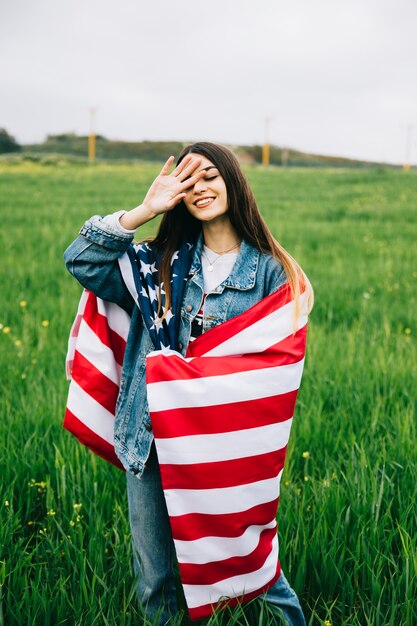 Senhora jovem, com, bandeira americana, ficar, em, campo