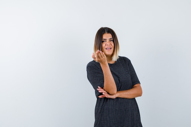 Senhora levantando a mão em gesto de questionamento em camiseta preta e parecendo perplexa. vista frontal.