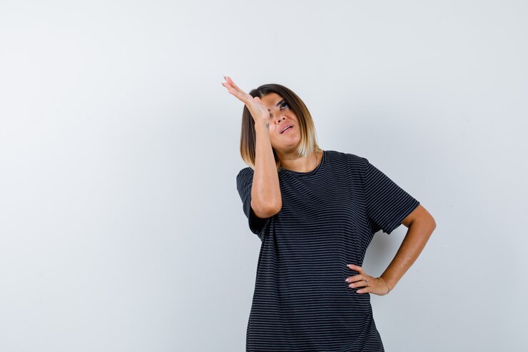 Foto grátis senhora levantando a mão enquanto olha para cima em uma camiseta preta e parece pensativa. vista frontal.