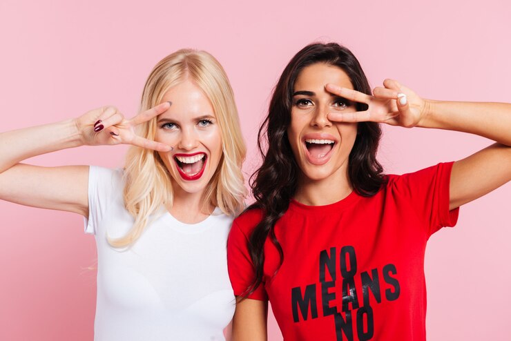 Foto grátis senhoras bonitas, mostrando o gesto de paz e sorrindo isolado