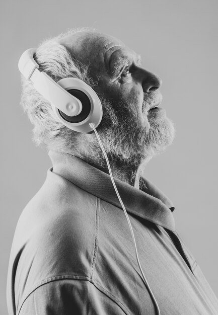 Senior de vista lateral com fones de ouvido