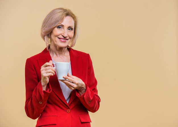 Foto grátis sênior mulher segurando uma xícara de café com espaço de cópia