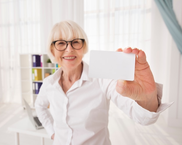 Senior, segurando um cartão de visita com espaço de cópia