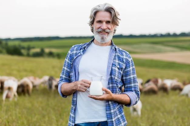 Foto grátis sênior segurando uma caneca com leite