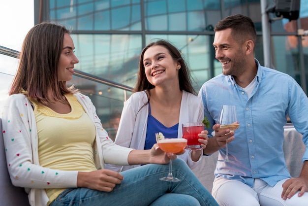 Sentado amigos com bebidas em uma festa