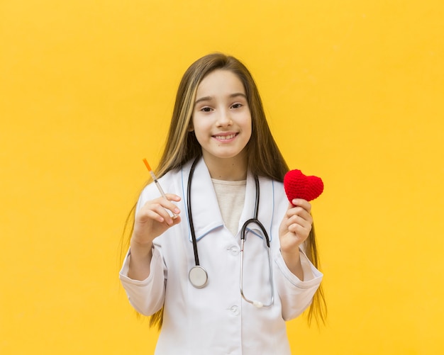 Foto grátis seringa e coração de exploração de menina