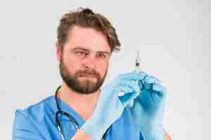 Foto grátis seringa nas mãos com luvas de homem de enfermeira