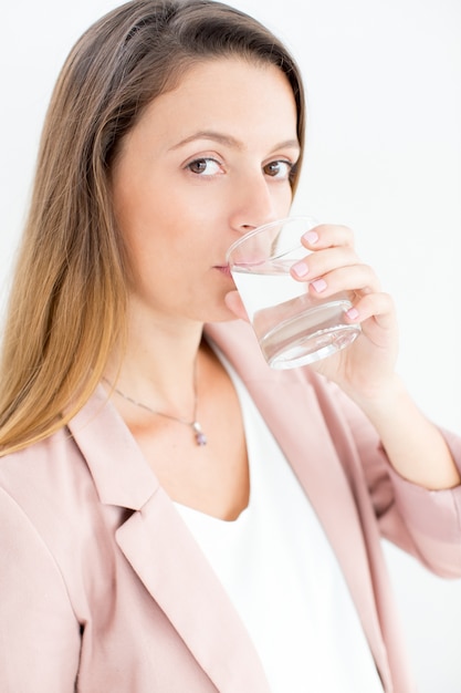 Sério jovem mulher de negócios bebendo água