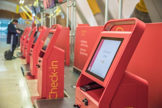 Serviço de check-in de máquinas automáticas vermelhas no quiosque do aeroporto