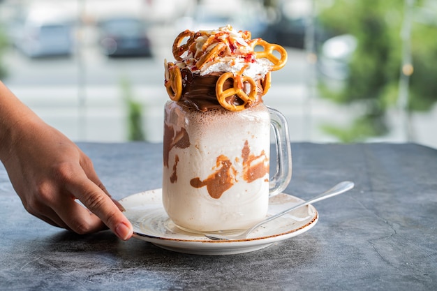 Shake leitoso de baunilha cremoso com pretzels em um pires branco
