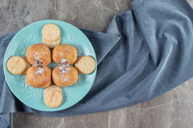 Shortbreads e biscoitos em um prato na toalha em mármore.