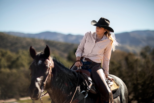 Silhueta de cowboy com cavalo contra luz quente