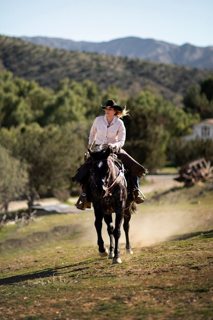 Silhueta de cowboy com cavalo contra luz quente