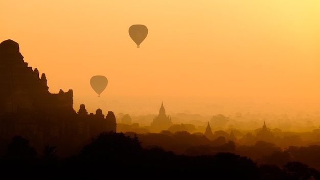 Silhueta de paisagem de cidade asiática com balões de ar quente