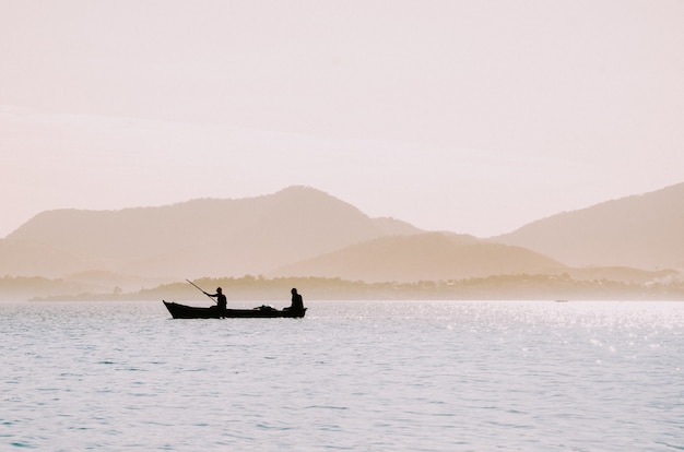 Foto grátis silhueta de pescadores em um pequeno barco