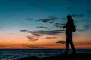 Foto grátis silhueta de pessoa pescando no mar