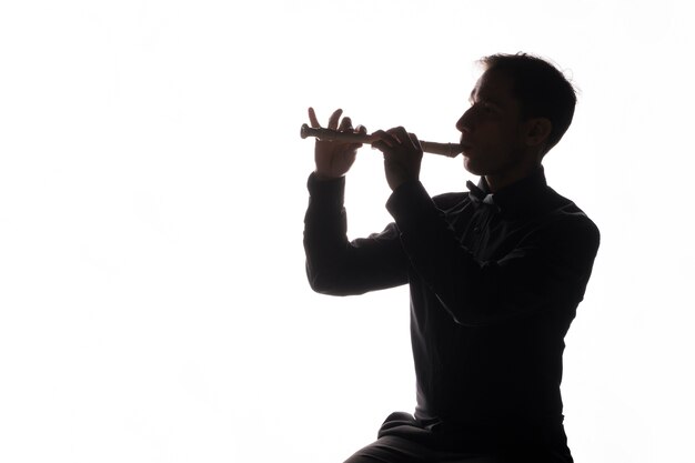 Silhueta de um homem tocando flauta